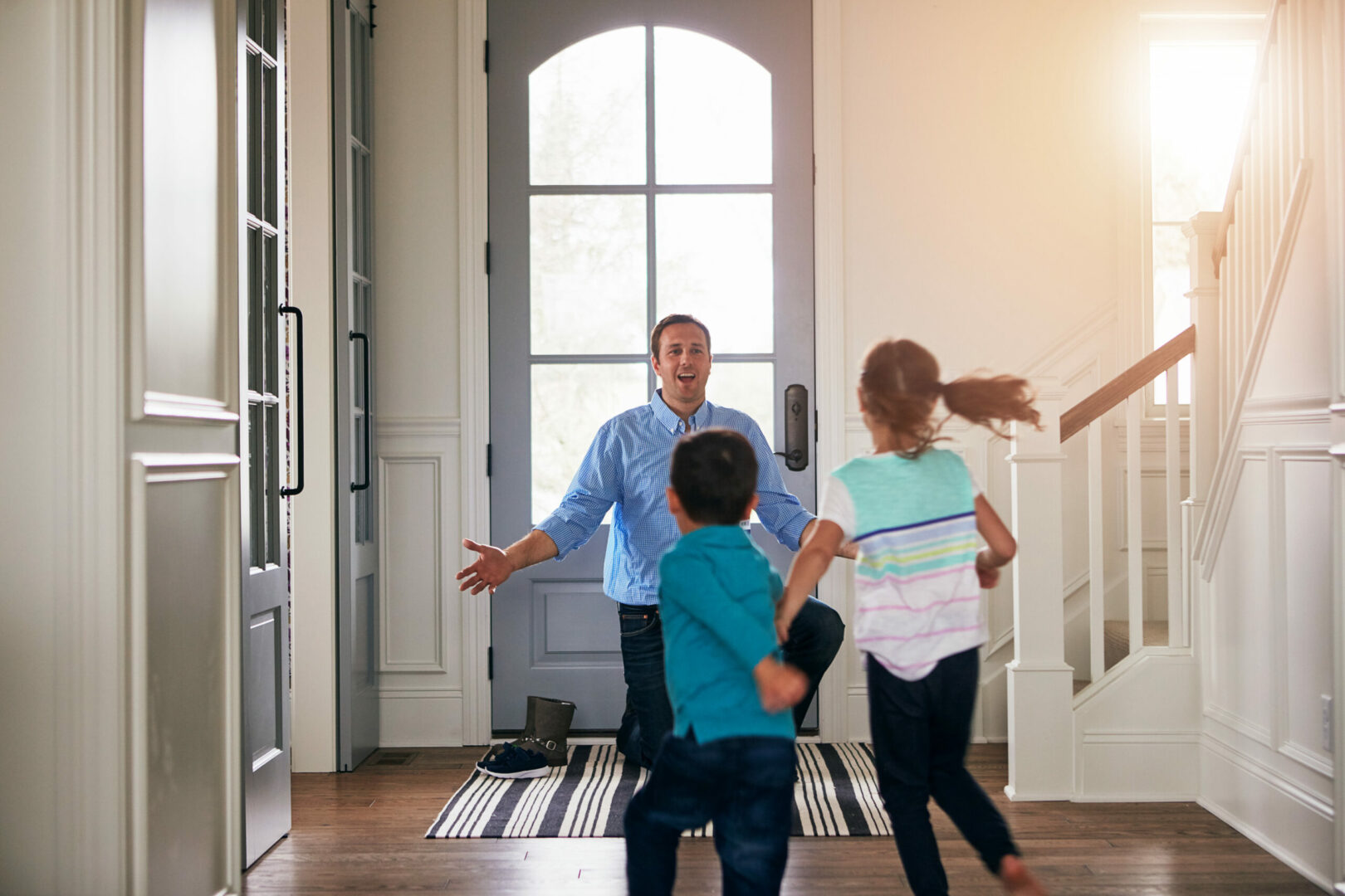 Shot of a father arriving home to a loving welcome from his son and daughter